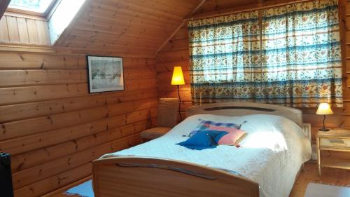 a bedroom with a bed in a log cabin at Vila Dovilas in Palanga