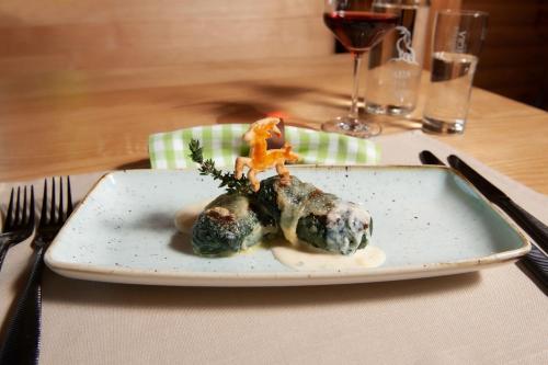 a plate of food with meatballs on a table at Hotel Ustria Parlatsch in Trin