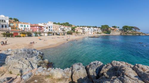 a view of a beach with people in the water at Atic Mar - Calella de Palafrugell in Calella de Palafrugell