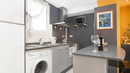 a kitchen with a sink and a washing machine in it at Atic Mar - Calella de Palafrugell in Calella de Palafrugell
