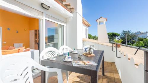 a table and chairs on a balcony with a lighthouse at Atic Mar - Calella de Palafrugell in Calella de Palafrugell