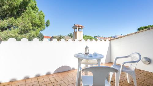 a patio with a table and chairs on a white fence at Atic Mar - Calella de Palafrugell in Calella de Palafrugell