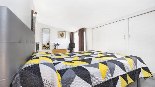 a bedroom with a black and yellow quilt on a bed at Atic Mar - Calella de Palafrugell in Calella de Palafrugell