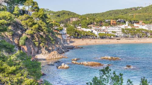 a view of a beach with people in the water at Atic Mar - Calella de Palafrugell in Calella de Palafrugell
