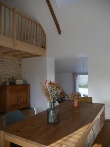 une cuisine avec une table en bois et des fleurs. dans l'établissement * LA CAMPAGNE AU BORD DE LA MER *, à Locoal-Mendon