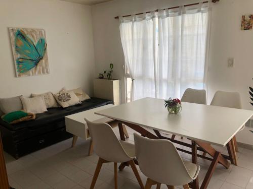 ein Wohnzimmer mit einem Tisch, Stühlen und einem Sofa in der Unterkunft Arenas B&B- Casa Compartida in Puerto Madryn