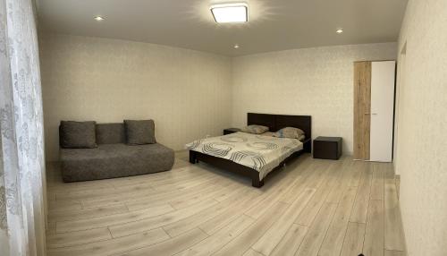 una camera con letto e divano di Квартира ЛАВИНА Room a Sumy