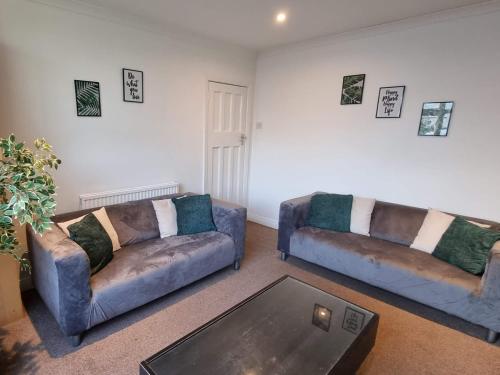 a living room with two couches and a coffee table at Mackie House by Cliftonvalley Apartments in Bristol