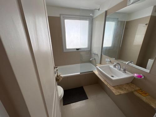 a bathroom with a sink and a toilet and a mirror at Departamento en Centro de Salta in Salta