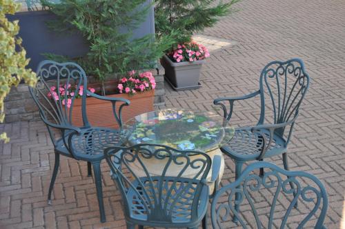 three chairs and a table with a glass table at Hotel Villa Liberty in Pontecurone