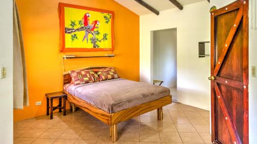 ein Schlafzimmer mit einem Bett mit einer orangefarbenen Wand in der Unterkunft Monte Terras in Tronadora