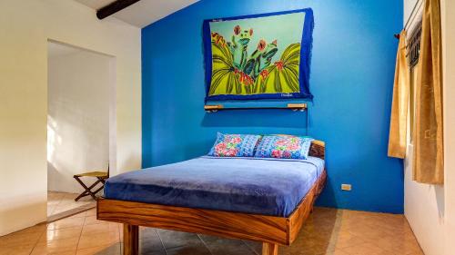 a blue room with a bed with a painting on the wall at Monte Terras in Tronadora
