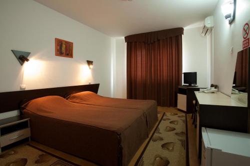 una camera d'albergo con letto e scrivania di Hotel Levisticum a Bacău