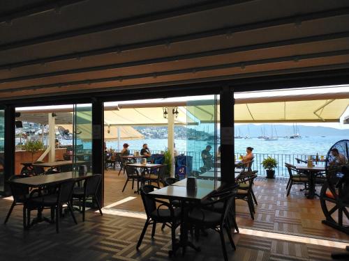a restaurant with tables and chairs and a view of the ocean at Gözen Hotel in Bodrum City
