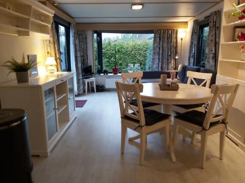 a kitchen and dining room with a table and chairs at Gezellig familie chalet tot 6 personen op de Veluwe Bungalowpark De Kern in Putten