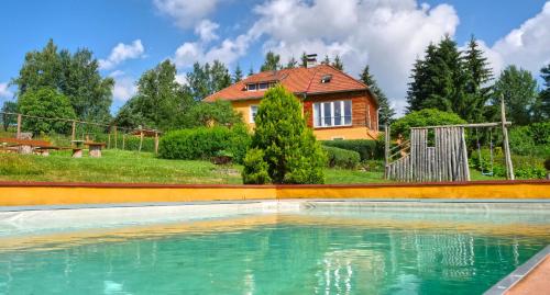 a house with a swimming pool in front of a house at Chalupa Jenín in Dolní Dvořiště