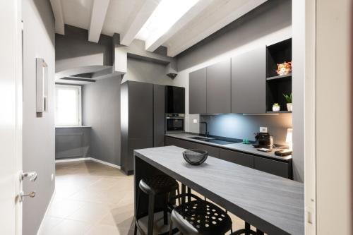 a kitchen with black cabinets and a wooden table at Carlo Suite Apartments con Vasca Idromassaggio in Palermo