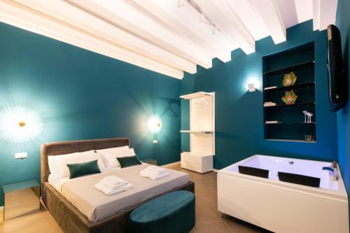 a blue bedroom with a bed and a bath tub at Carlo Suite Apartments con Vasca Idromassaggio in Palermo