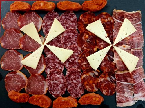a tray of different types of meats and cheese at Hotel Santa Cecilia in Ciudad Real