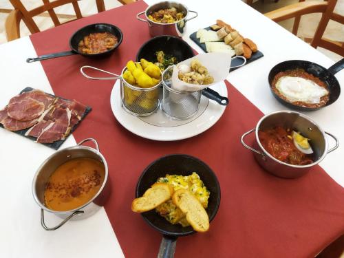 a table with many bowls of food on it at Hotel Santa Cecilia in Ciudad Real