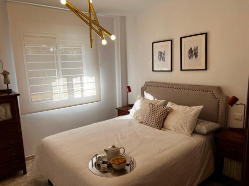 リンコン・デ・ラ・ビクトリアにあるApartamento Acebuche 34 - Newly renovatedのベッドルーム1室(ベッド1台、食料品のトレイ付)