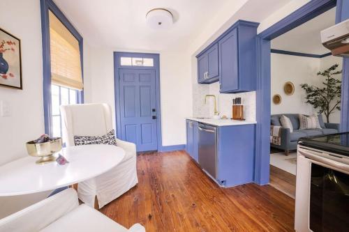 a kitchen with blue cabinets and a white table at Guesthouse Charleston EAST 42 C in Charleston