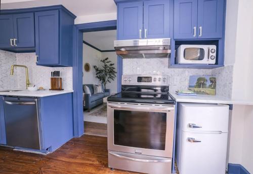 a kitchen with blue cabinets and a stove and a microwave at Guesthouse Charleston EAST 42 C in Charleston