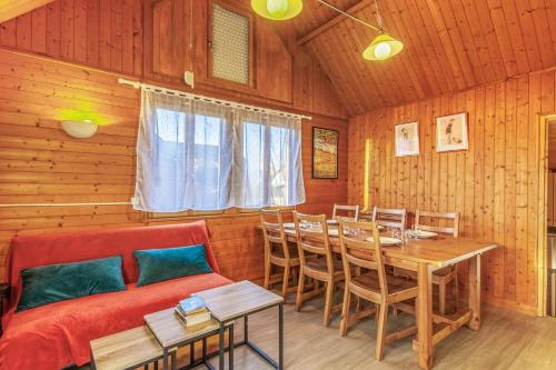 a living room with a couch and a table and chairs at Calm chalet close to Cabourg center - Welkeys in Cabourg