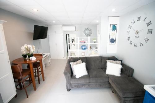 ein Wohnzimmer mit einem Sofa und einem Tisch in der Unterkunft Stacys Place #3 Studio Apartment in Port of Spain