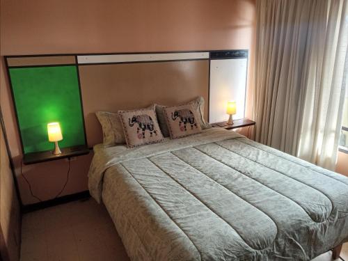 a bedroom with a large bed with two lamps at Tu Jardín Secreto in La Serena