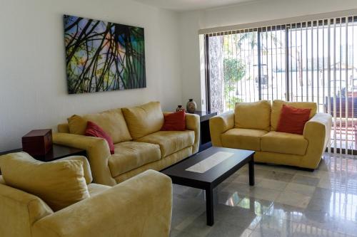 a living room with two couches and a coffee table at Villas La Marina in Cancún