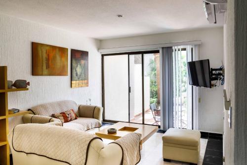 a living room with two couches and a tv at Villas La Marina in Cancún