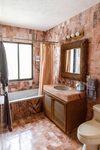 a bathroom with a sink and a tub and a toilet at Villas La Marina in Cancún
