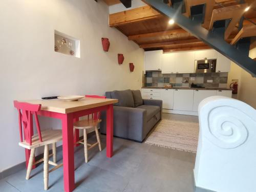 a living room with a red table and a couch at Chão da Velha - Casas de Campo in Nisa