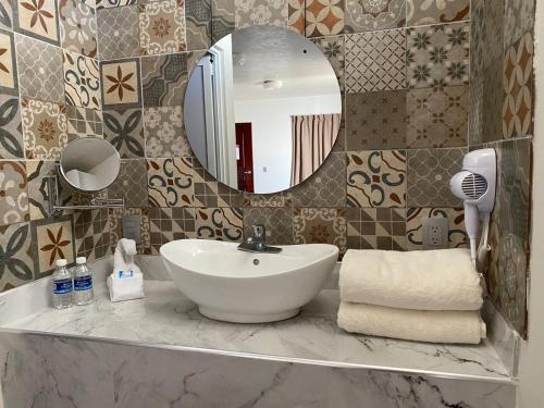 a bathroom with a sink and a mirror at Hotel Awazul Bacalar in Bacalar