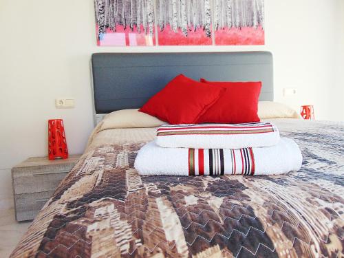 a bedroom with a bed with red pillows on it at Luxury EL BRILLANTE Apartament in Fuengirola