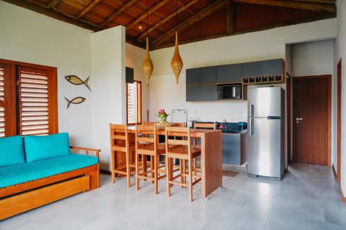 uma cozinha com um frigorífico, uma mesa e cadeiras em Casa TRIP - 2 suítes na praia de Taipu de Fora em Taipu