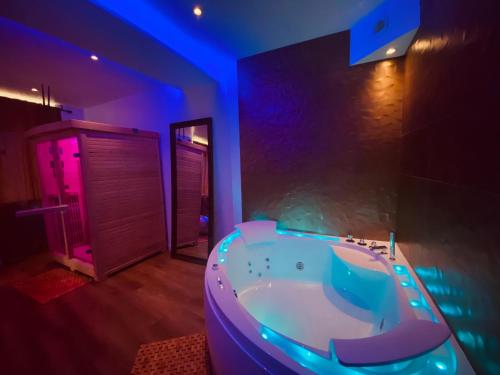 La salle de bains est pourvue d'une baignoire avec un éclairage violet. dans l'établissement Le Rêve d'une Nuit, à Bitche