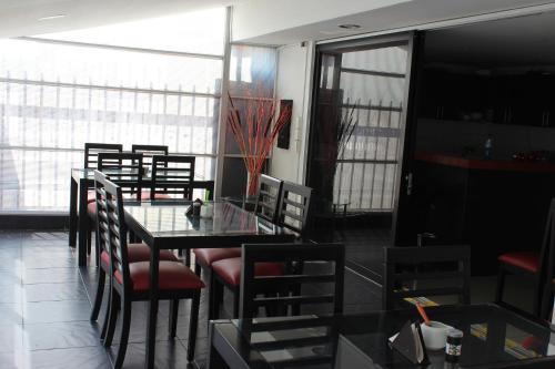 een eetkamer met een glazen tafel en stoelen bij Hotel Montecarlo Boutique in Bogota