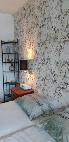 a bedroom with a bed and a table with a wall at Haus Stefanie Elvire in Kurort Altenberg