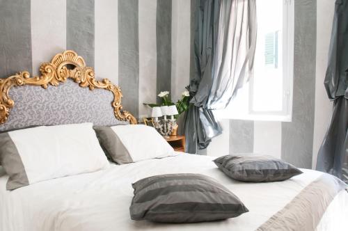 una camera con un letto con due cuscini sopra di BIBI BOUTIQUE AREZZO Cartazucchero - Cioccolato ad Arezzo