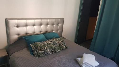 - un lit avec une tête de lit et un oreiller dans l'établissement Maison sud des Landes proche Seignosse/ Capbreton / Soustons, à Tosse