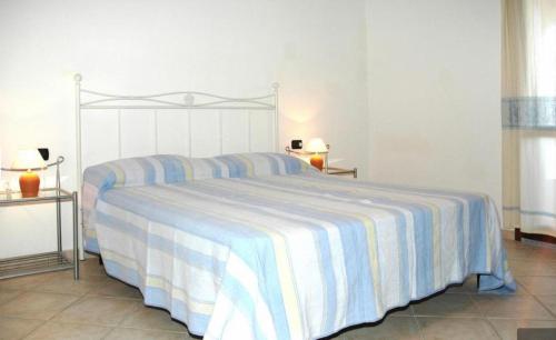 a bedroom with a large bed with a striped blanket at La Cinta in San Teodoro