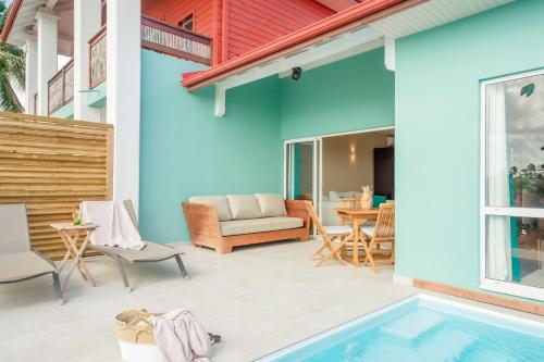 a patio with a swimming pool next to a house at Suites Anagani in Le François