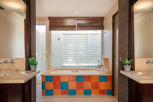een badkamer met een groot bad en een raam bij Suites Anagani in Le François