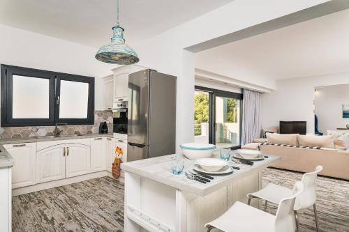a kitchen and living room with white cabinets at Villa Tania Samos in Samos