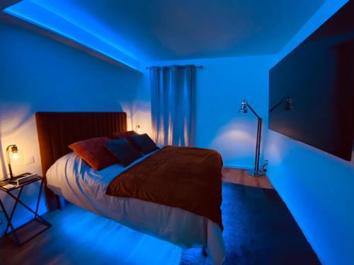 1 dormitorio con 1 cama con luz azul en Le Rêve d'une Nuit, en Bitche