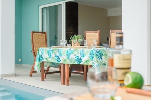 a dining room table with a blue and green table cloth at Suites Anagani in Le François