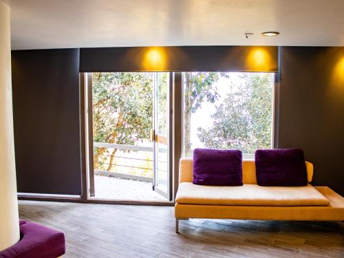 a living room with a couch and a large window at San Antonio Hotel Boutique in Santiago Matatlán