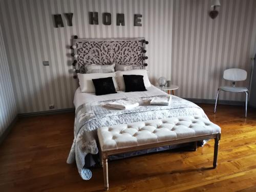 a bedroom with a king sized bed with a white tufted bedspread at La Mirabelle des 3 Forêts in Bricon